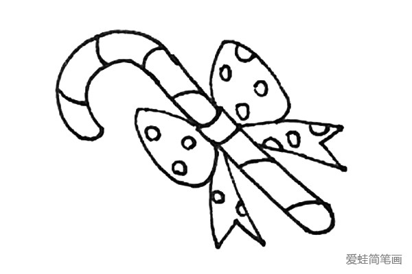 第八步：还需要用弧线给拐杖糖画上纹理，以及在蝴蝶结上画上圆形的装饰。