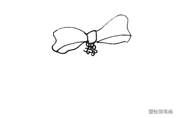 第三步：在蝴蝶结下面画上一些像葡萄形状的装饰品。